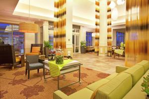 eine Lobby mit einem Sofa, einem Tisch und Stühlen in der Unterkunft Hilton Garden Inn Minneapolis/Eden Prairie in Eden Prairie