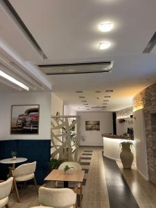 a lobby with tables and chairs and a car on the wall at Hotel Porto A in Ulcinj