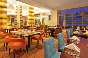 ein Restaurant mit Tischen und Stühlen in einem Raum in der Unterkunft Hilton Garden Inn Minneapolis/Eden Prairie in Eden Prairie