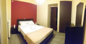 a bedroom with a white bed with a red wall at Calma Luxury House in Marmari