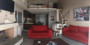 a living room with two red chairs and a fireplace at Calma Luxury House in Karistos