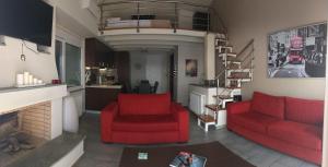 a living room with two red chairs and a fireplace at Calma Luxury House in Marmari