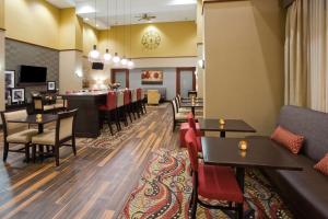 a restaurant with tables and chairs and a bar at Hampton Inn & Suites Lino Lakes in Lino Lakes
