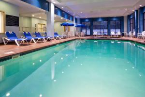 una grande piscina con sedie blu e ombrelloni di Hampton Inn & Suites Lino Lakes a Lino Lakes
