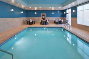 una piscina in una stanza d'albergo con tavoli e sedie di Hampton Inn Lakeville Minneapolis, Mn a Lakeville
