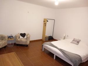 1 dormitorio con cama, silla y espejo en Snow Guest House, en Santarém