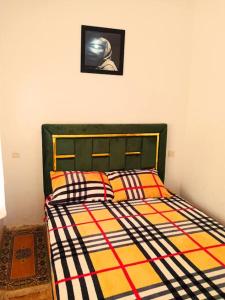 uma cama num quarto com uma fotografia na parede em Découvrez les montagnes de l'Ourika, l'Atlas du Maro-c em Marrakech