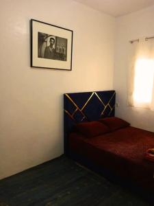 ein Schlafzimmer mit einem Bett und einem Bild an der Wand in der Unterkunft Découvrez les montagnes de l'Ourika, l'Atlas du Maro-c in Marrakesch