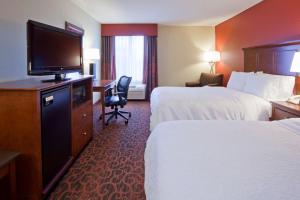 ein Hotelzimmer mit 2 Betten und einem Flachbild-TV in der Unterkunft Hampton Inn Minneapolis Northwest Maple Grove in Maple Grove