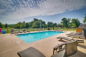 a swimming pool with chaise lounge chairs at Fayetteville Vacation Rental with Deck and Shared Pool in Fayetteville