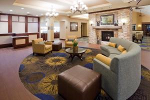 a lobby with couches and chairs and a fireplace at Homewood Suites New Brighton in Roseville
