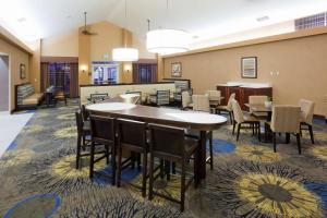a dining room with tables and chairs in a lobby at Homewood Suites New Brighton in Roseville
