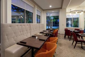 a restaurant with tables and chairs and windows at Hilton Garden Inn Minneapolis Saint Paul-Shoreview in Shoreview