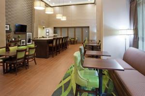 a restaurant with tables and chairs and a bar at Hampton Inn & Suites Minneapolis West/ Minnetonka in Minnetonka