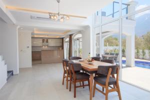 a kitchen and dining room with a wooden table and chairs at Orka World Villa 2 in Oludeniz