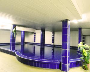 a swimming pool in a building with a man standing next to it at Hotel Plaza Center in Santa Cruz de la Sierra