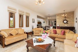 ein großes Wohnzimmer mit Sofas und einem Tisch in der Unterkunft Villa Erato in Nea Dimmata