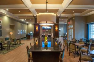 a lobby of a hotel with tables and chairs at Hampton Inn & Suites New Orleans/Elmwood in Harahan