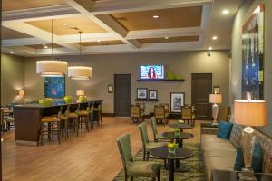 a hotel lobby with a bar and a tv at Hampton Inn & Suites New Orleans/Elmwood in Harahan