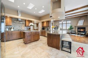 a large kitchen with wooden cabinets and a large island at Elena's Sandia Sanctuary - An Irvie Home in Albuquerque
