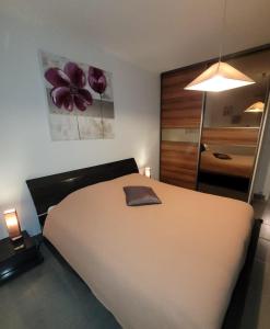 1 dormitorio con 1 cama grande y una pintura floral en la pared en Welcome, en Nantes