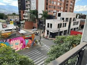 een balkon met uitzicht op een straat met graffiti bij Asombroso Apto 302 Para Grupos en El Poblado in Medellín