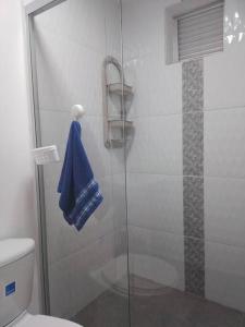 een badkamer met een douche en een blauwe handdoek bij Asombroso Apto 302 Para Grupos en El Poblado in Medellín