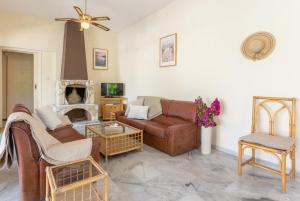 un soggiorno con mobili in pelle e camino di Villa Anemone a Polis Chrysochous