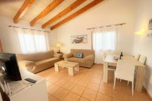 a living room with a couch and a table at Villa Mar Uno in Cala'n Bosch
