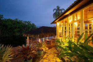 una casa con plantas delante de ella por la noche en Pousada Una, en Barra do Una