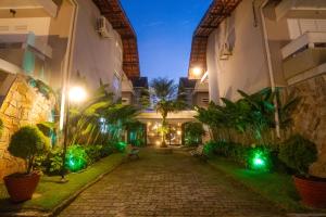 a courtyard of a building at night with green lights at Pousada Una in Barra do Una