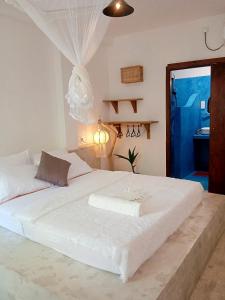 ein großes weißes Bett in einem Zimmer mit Fenster in der Unterkunft Sri Lanka Surf Villa Domus Graziella in Ahangama