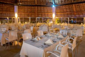 a banquet hall with white tables and white chairs at Viva Maya by Wyndham, A Trademark All Inclusive Resort in Playa del Carmen