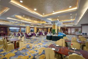 un salón de banquetes con mesas y sillas en un hotel en Ramada Plaza by Wyndham Chongqing West, en Dazu