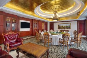 a dining room with a table and chairs and a chandelier at Ramada Plaza by Wyndham Chongqing West in Dazu