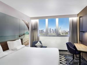 a hotel room with a bed and a desk and a window at Novotel Sao Paulo Morumbi in São Paulo