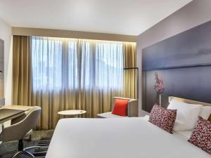 um quarto de hotel com uma cama grande e uma secretária em Novotel Sao Paulo Morumbi em São Paulo