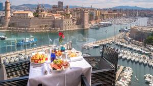 uma mesa com dois pratos de comida em cima de uma cidade em Sofitel Marseille Vieux-Port em Marselha