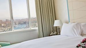 - une chambre avec un lit et une grande fenêtre dans l'établissement Sofitel Marseille Vieux-Port, à Marseille