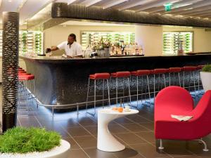 a man standing at a bar in a restaurant at Novotel Marseille Vieux Port in Marseille