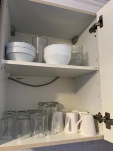 巴纽Bel appartement proche Paris métro 4的一个带碗和玻璃罐的厨房架