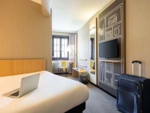 une chambre d'hôtel avec un lit et un ordinateur portable. dans l'établissement ibis Hotel Brussels off Grand'Place, à Bruxelles