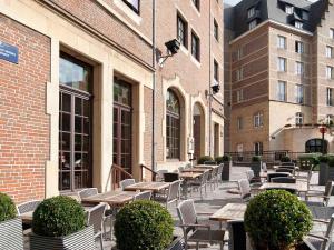 um pátio exterior com mesas, cadeiras e edifícios em ibis Hotel Brussels off Grand'Place em Bruxelas
