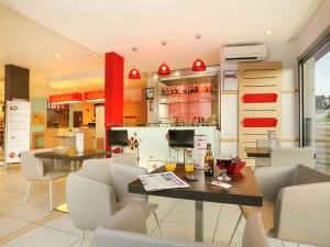 a restaurant with a table and chairs and a bar at Ibis Brive Centre in Brive-la-Gaillarde