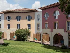 a building with a grass yard in front of it at Mercure Antibes Sophia Antipolis in Valbonne