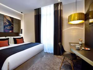 a hotel room with a bed and a desk at Grand Hotel La Cloche Dijon - MGallery in Dijon