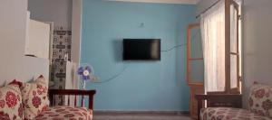 un salon avec un canapé et une télévision sur un mur bleu dans l'établissement amine adnane, à Safi