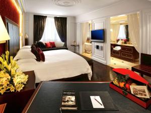 a hotel room with a bed and a television at Sofitel Legend Metropole Hanoi in Hanoi
