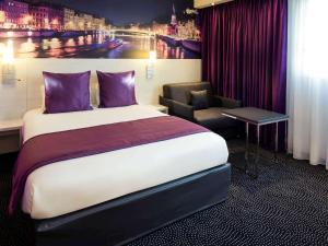 ヴィルールバンヌにあるHôtel Mercure Lyon Centre Charpennes Parc de la Tête d'Orのベッドと椅子付きのホテルルーム