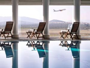 a row of chairs on an airport terminal with an airplane at Sofitel Athens Airport in Athens
